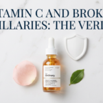 Vitamin C serum with rose petals and shield prop on white marble in delicate pink tones