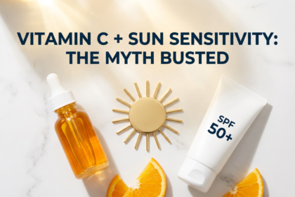 Vitamin C serum and sunscreen tube with sun disc prop on white marble in warm golden tones