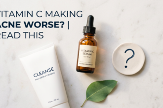Vitamin C serum and cleanser with question mark prop on white stone in sage green tones