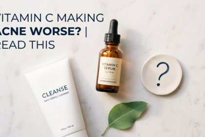 Vitamin C serum and cleanser with question mark prop on white stone in sage green tones